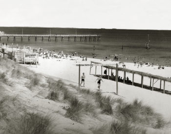 Looking north to the jetty from the Cottesloe Surf Lifesaving Club boathouse and Scoota Car track. Marram grass, planted to stablise the dunes, is growing in the foreground 1938